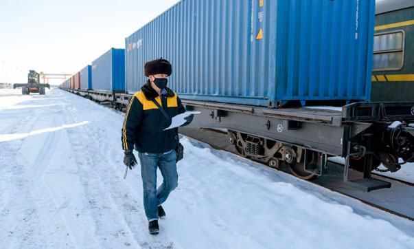 2020年2月20日，在中欧班列乌鲁木齐集结中心，货车检车员在核对集装箱编号。摄影/丁磊（新华社）