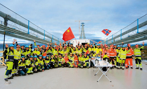 2017年10月，四川路桥项目部全体参建者与来自挪威、冰岛、瑞典等多国的合作伙伴庆祝大桥成功合龙。（四川路桥供图）